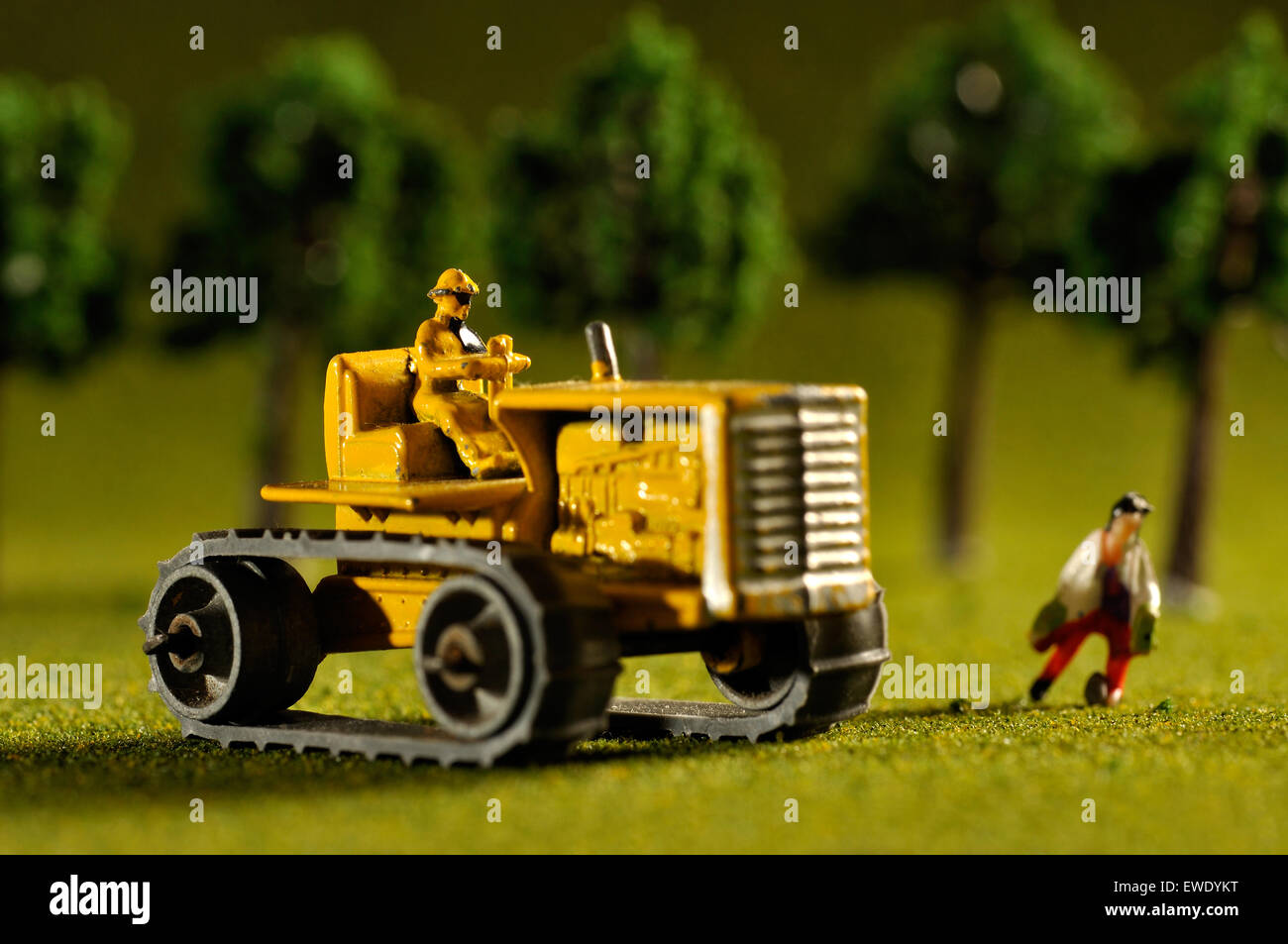 Modell Caterpillar Traktor mit Miniatur-Person im Studio Einstellung Stockfoto