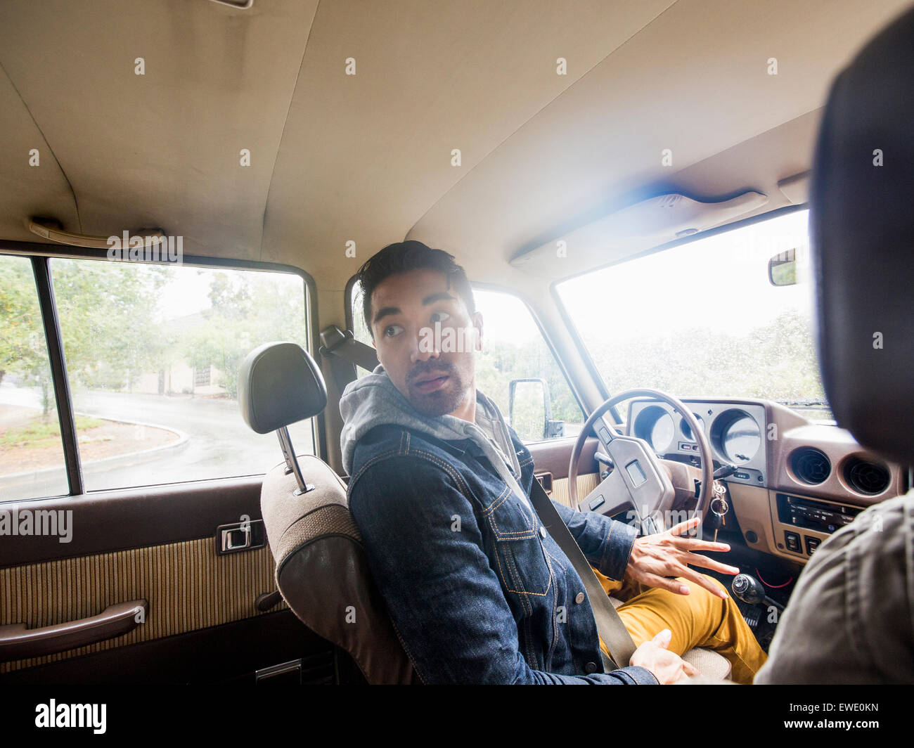 Junger Mann in einem Auto, in der Fahrersitz über die Schulter schauen Stockfoto