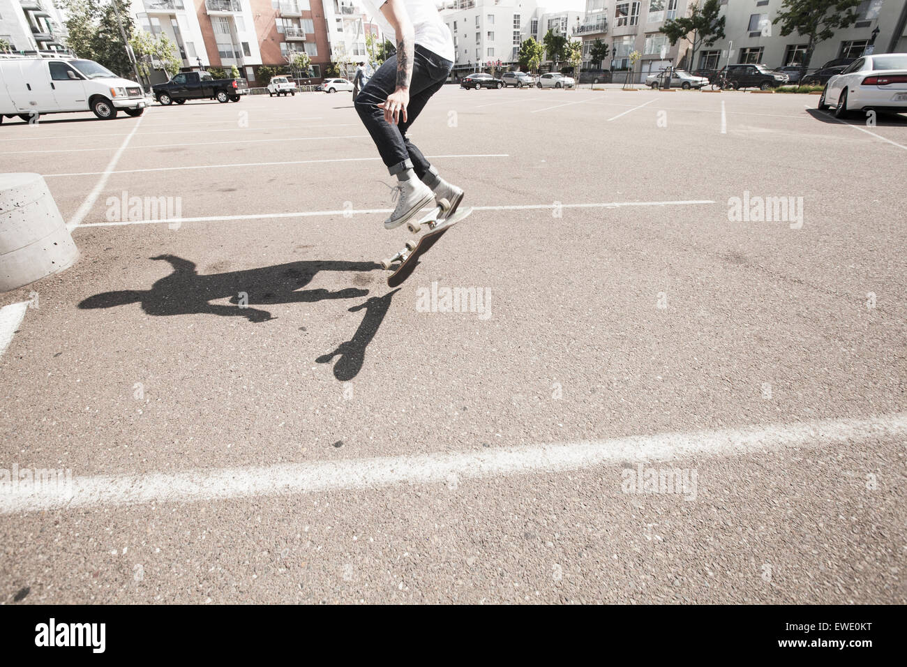 Junger Mann Skateboarden auf einem Parkplatz Stockfoto