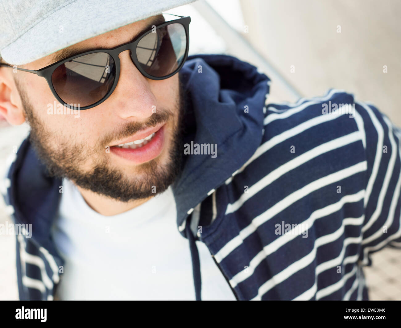 Porträt von einem lächelnden jungen Mann mit Sonnenbrille Stockfoto