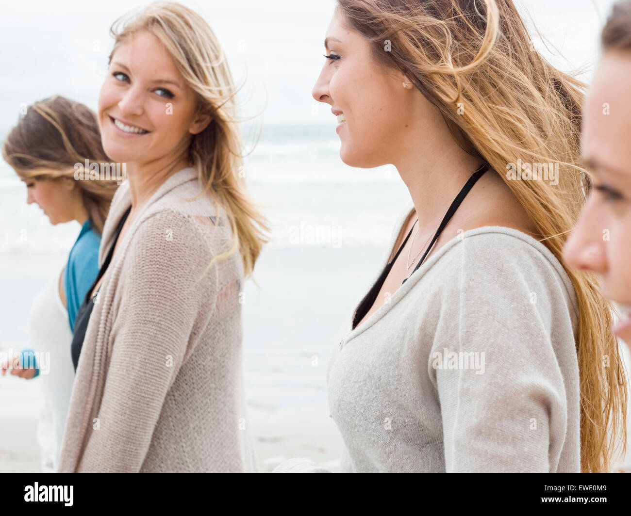 Eine Gruppe von lächelnden junge Frauen zu Fuß am Strand Stockfoto