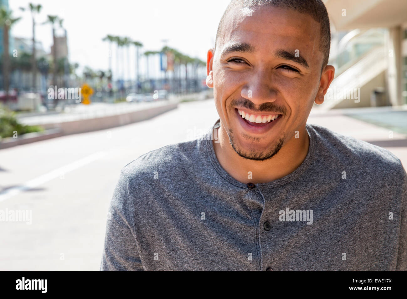 Porträt eines lächelnden jungen Mannes stehend in einer Straße Stadtleben Stockfoto
