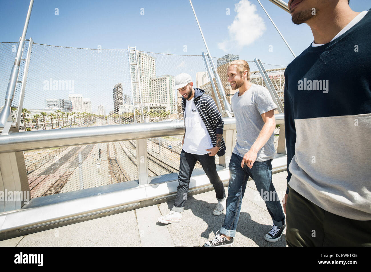 Gruppe junger Männer zu Fuß entlang der Fußgängerbrücke Stockfoto