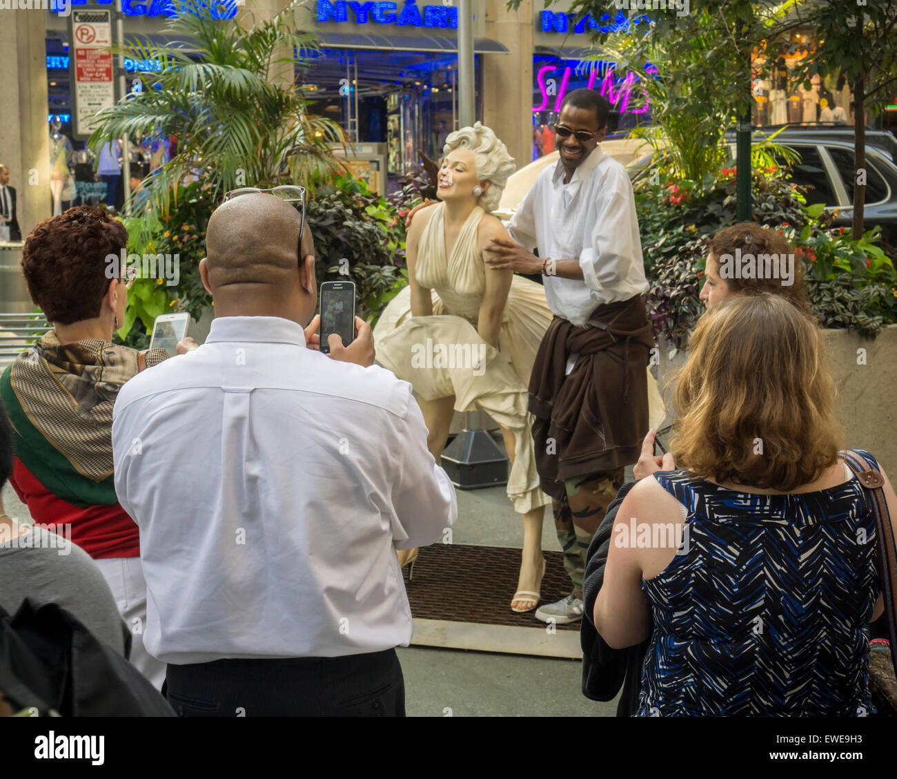 Passant interagieren mit Forever Marilyn vom Künstler Seward Johnson auf dem Broadway Fußgängerzone Plätze im Garment District in New York auf Montag, 22. Juni 2015. Achtzehn Jahren gemalt lebensgroße Bronze-Skulpturen von Johnson Gnade die Plazas, einige der berühmten Fotos und andere alltägliche Menschen alltägliche Dinge zu tun. Die Ausstellung wird bis zum 15. September sein. (© Richard B. Levine) Stockfoto