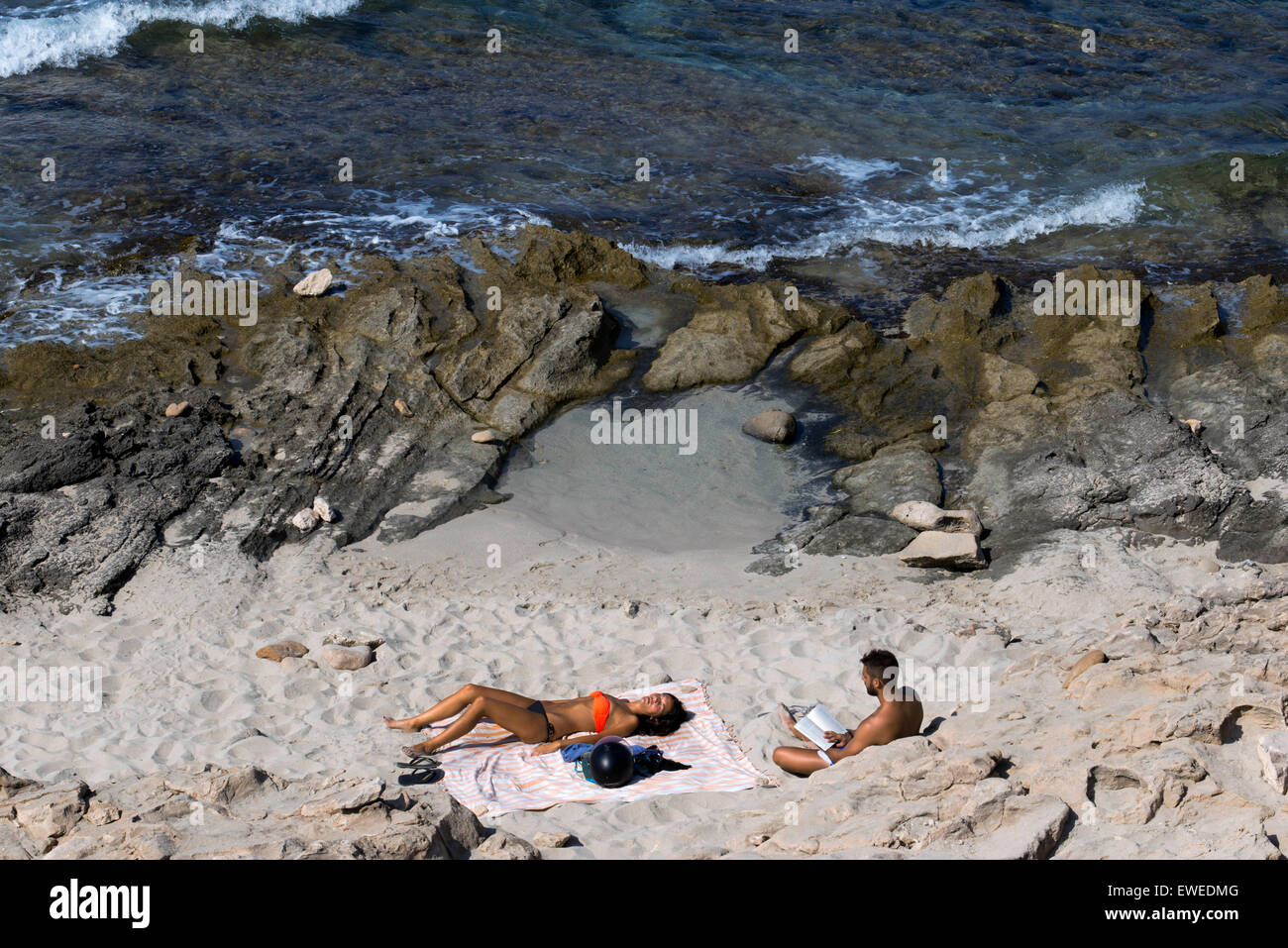 Lesen und entspannen Sie sich in Es Caló des Mort Strand Migjorn Beach, Formentera, Balearen Inseln, Spanien. Entscheidungsträger, Touristen, Es Caló des Mort, Strand, Urlaub Formentera, Pityusen, Balearen, Spanien, Europa. Stockfoto
