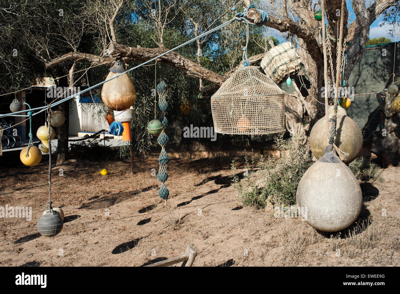 Angeln-Instrumente mit Netzen Longlines Boje Tackle im Vordergrund hangin in einem Baum auf Formentera, Balearen, Spanien. Mittelmeer. Formentera Balearen Angelgeräte Netze Longliner Trawler limitieren. Stockfoto