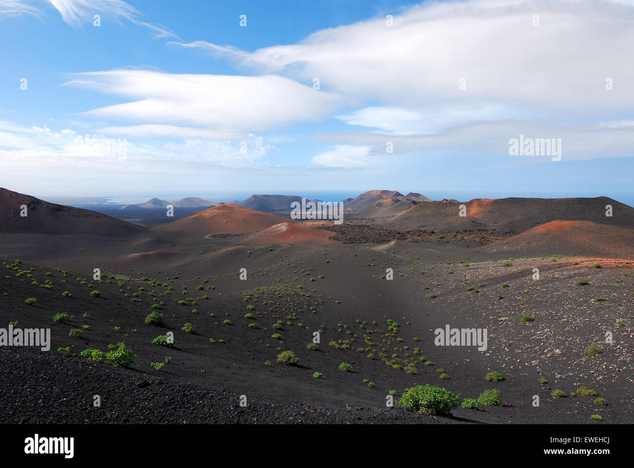 Lanzarote, Kanarische Inseln, Spanien. Berge von Brand und kleine grüne Büsche im Timanfaya Nationalpark. Stockfoto