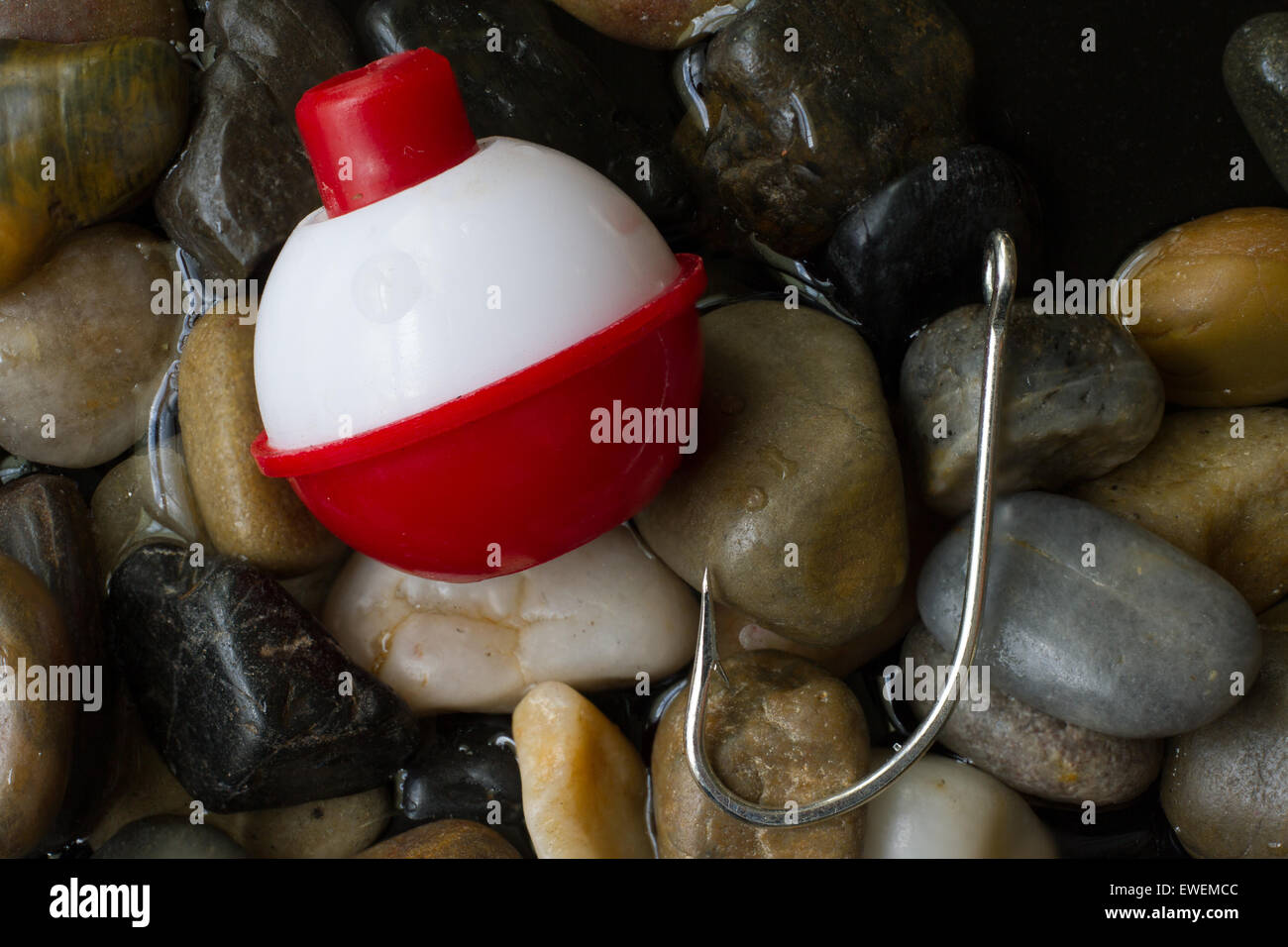 Ein Blinker und Haken ruht auf Steinen. Stockfoto