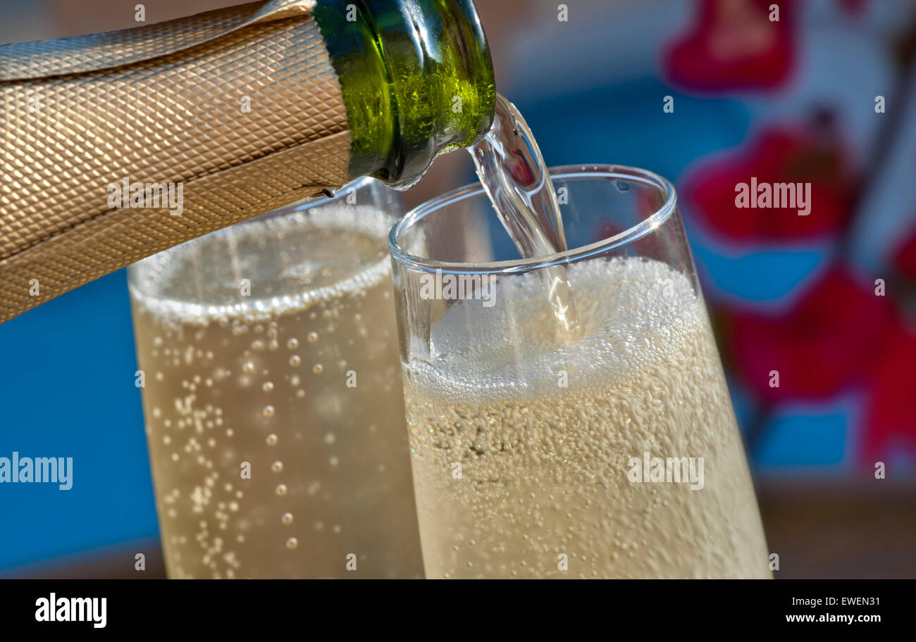 Gießen SEKT IM FREIEN in der Nähe Blick auf Gießen gekühlte Gläser Champagner auf der sonnenbeschienenen Terrasse mit Bougainvillea Blumen und Pool im Hintergrund Stockfoto