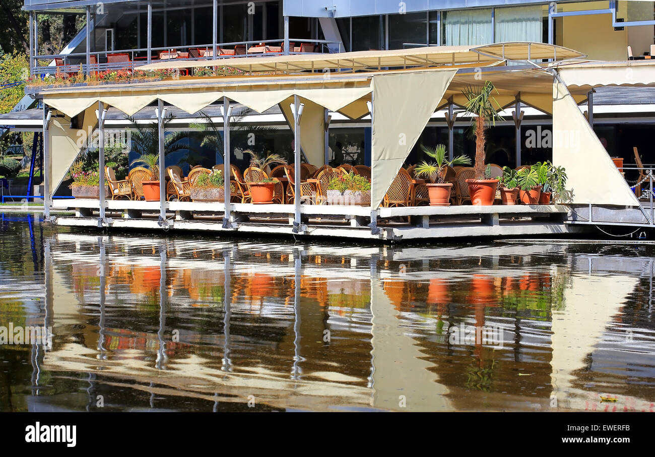 Open-Air-Café in der Nähe von Teich im Stadtpark Stockfoto