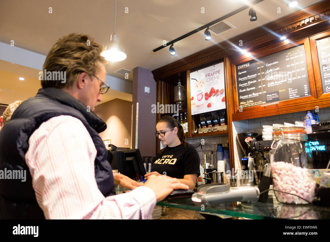Caffe Nero Gast; ein Gast, der an der Bar von einem Barista, Caffe Nero, Newmarket Suffolk UK, bedient wird Stockfoto