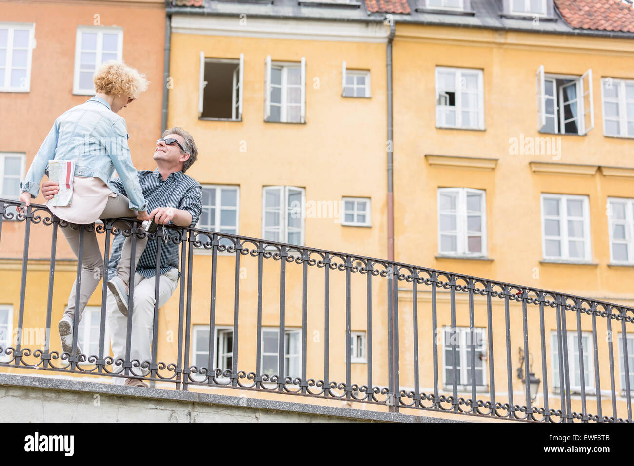 Niedrigen Winkel Ansicht der liebenden paar mittleren Alters durch Geländer gegen Gebäude Stockfoto