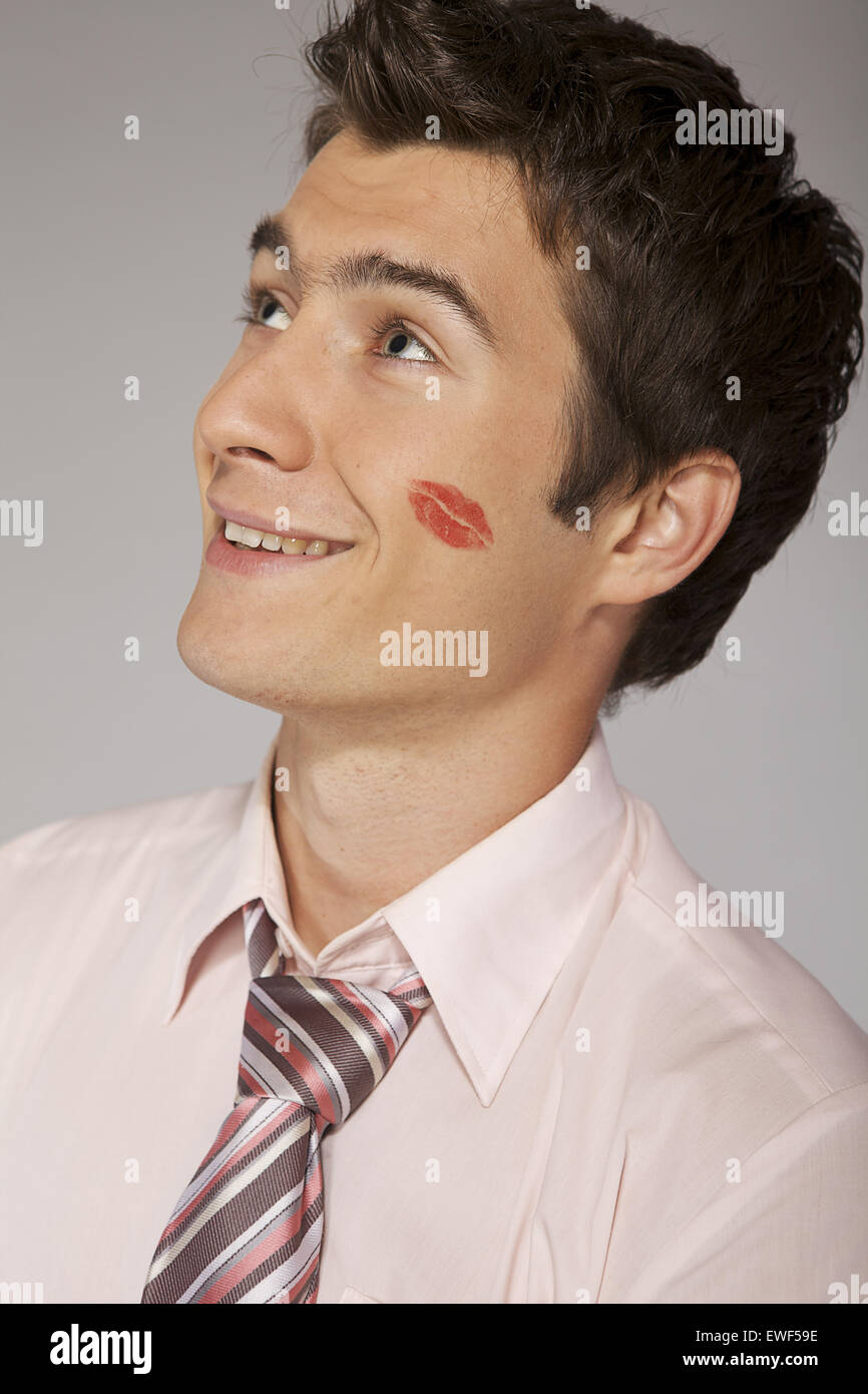 Kaukasische Jungunternehmer mit Lippenstift Mark auf die Wange küssen Stockfoto