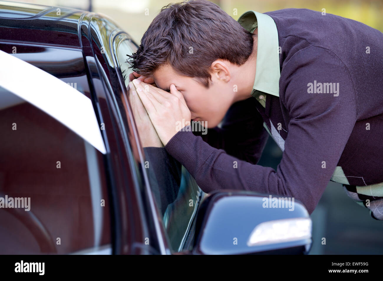 Junger Mann, Blick auf Neuwagen Stockfoto