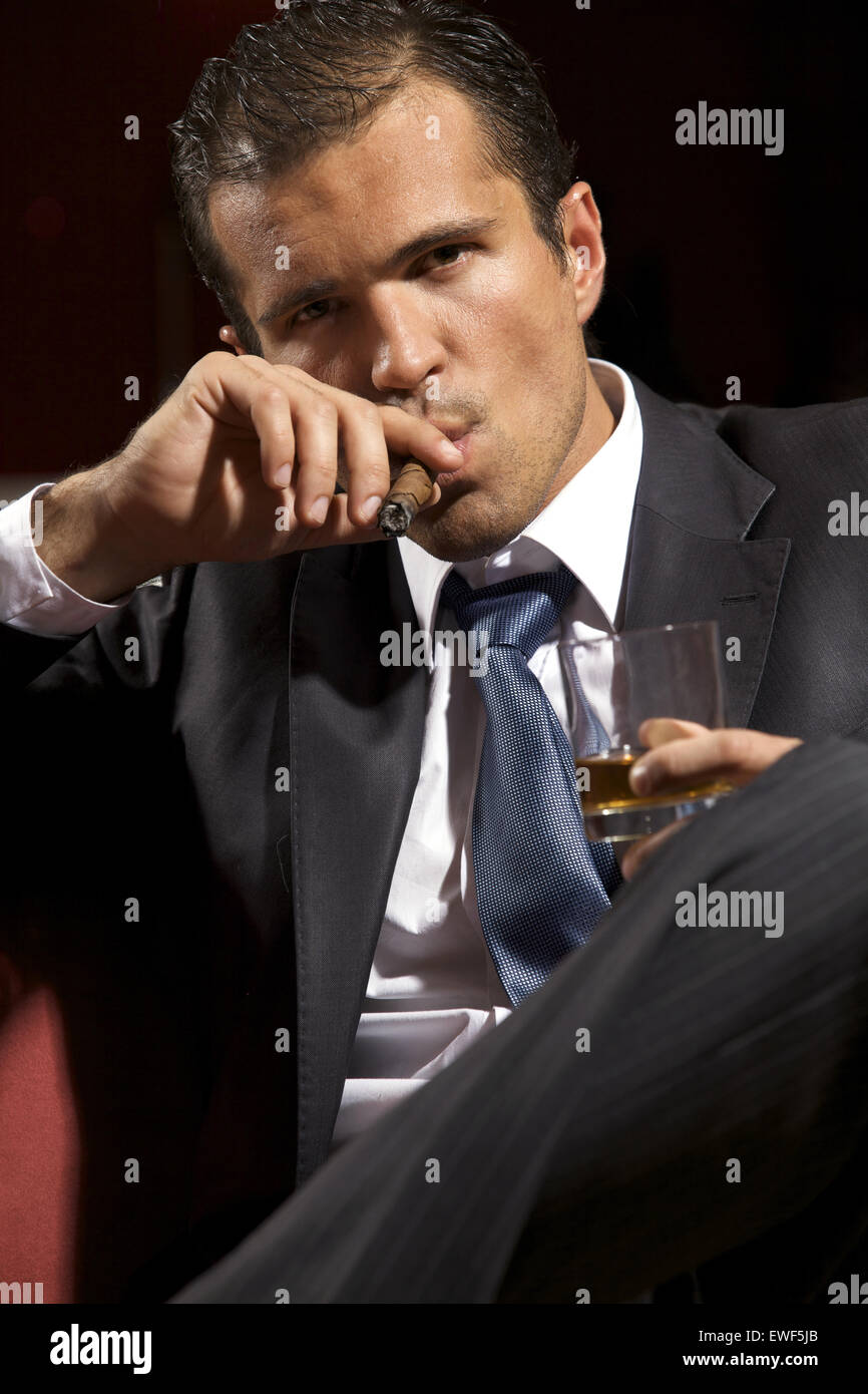 Porträt des jungen Mann Rauchen Zigarre und Holding Weinglas Stockfoto