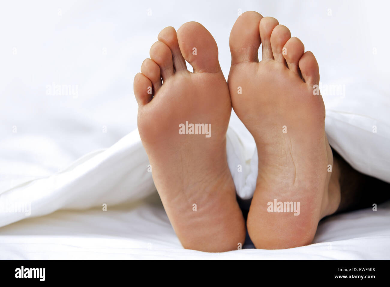 Jemandes Fuß im Bett, Nahaufnahme Stockfoto