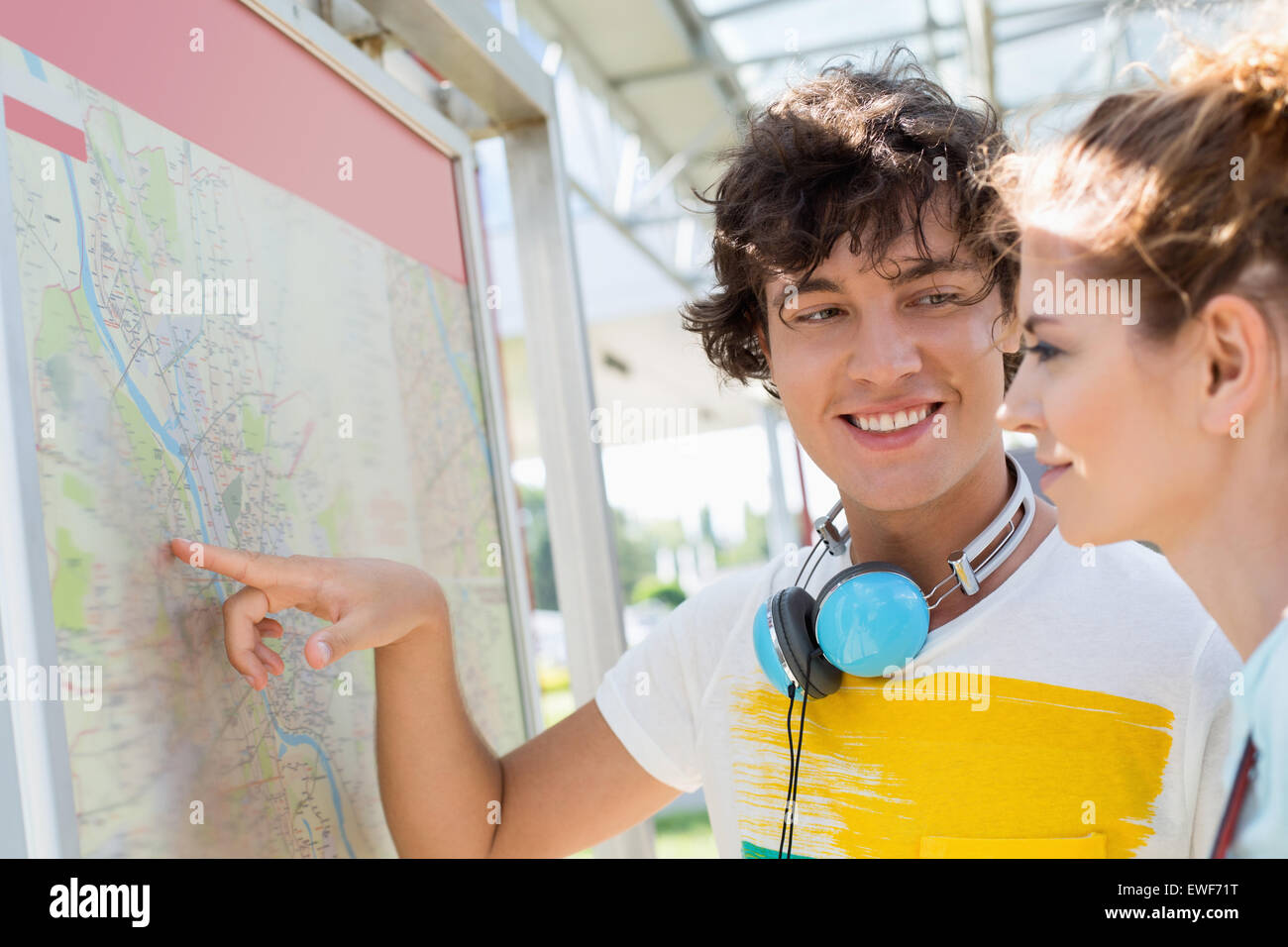 Glücklicher Mann zeigt Orte auf Karte Frau im freien Stockfoto