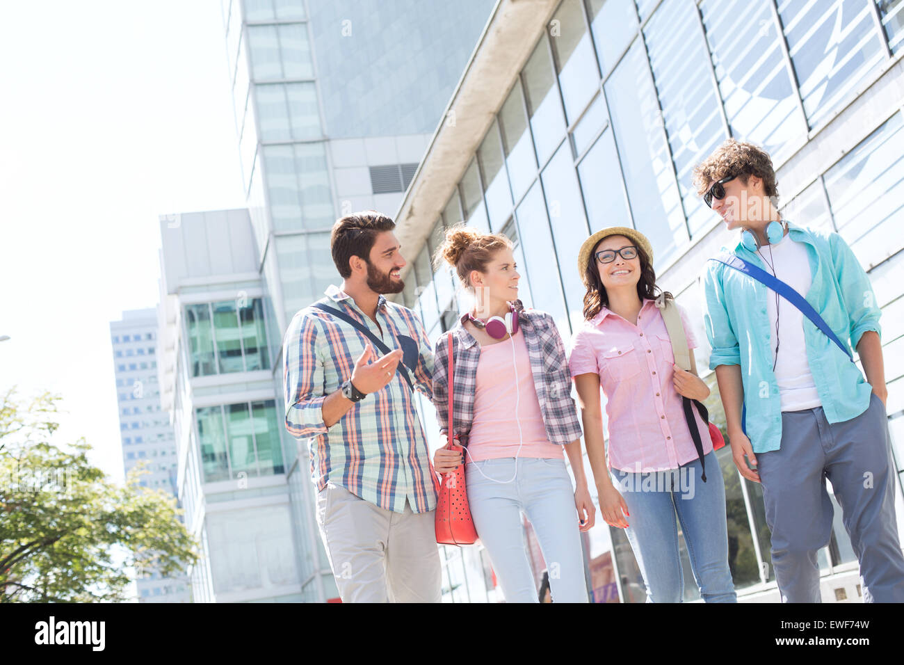 Glücklich männliche und weibliche Freunde zu Fuß außerhalb Bürogebäude Stockfoto