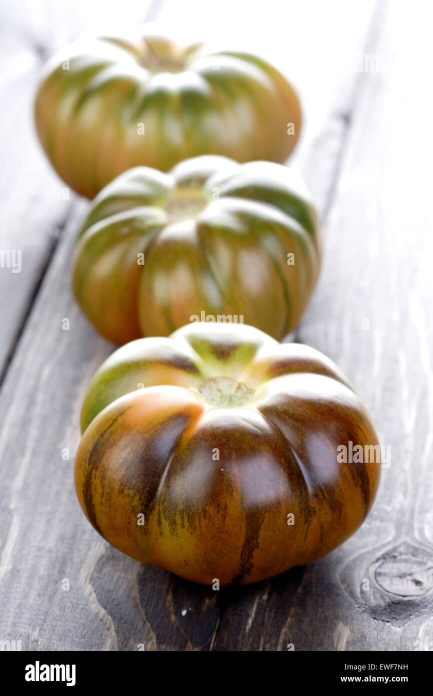 Schwarze Tomaten auf Holztisch Stockfoto