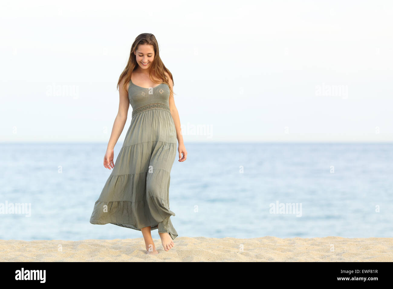 Ehrliche feminine Träumer Mädchen zu Fuß genießen unbeschwert auf dem Sand des Strandes in Richtung Kamera Stockfoto