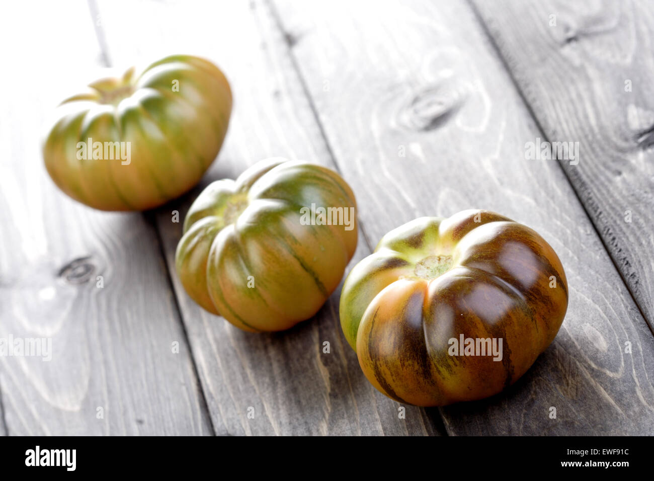 Studioaufnahme von schwarzen Tomaten auf weißem Hintergrund Stockfoto