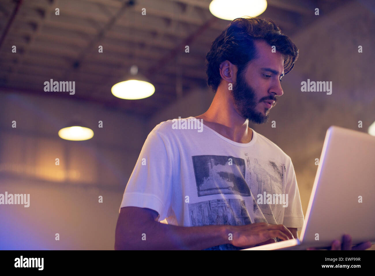 Lässige Geschäftsmann mit Laptop im Büro Stockfoto