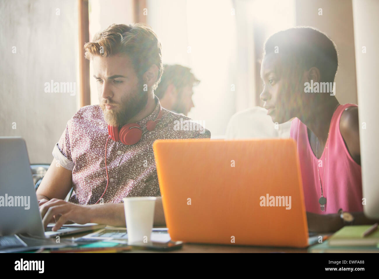 Lässige Geschäftsleute arbeiten bei Laptops im Büro Stockfoto