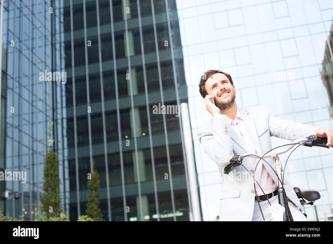 Niedrigen Winkel Ansicht der Geschäftsmann Beantwortung Handy beim Sitzen auf dem Fahrrad im freien Stockfoto