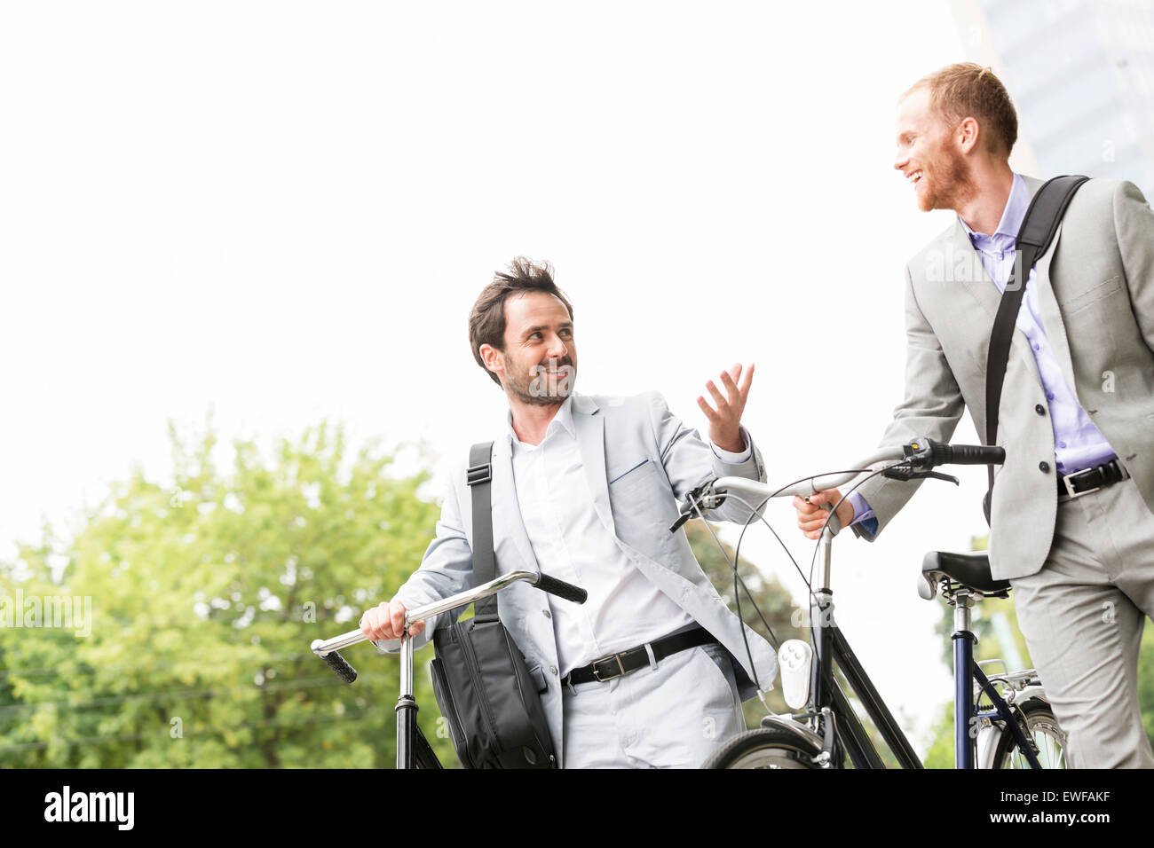 Geschäftsleute sprechen während des Gehens mit Fahrrädern im freien Stockfoto