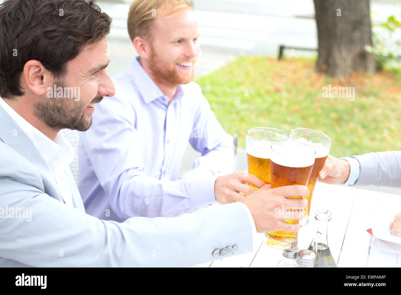Geschäftsleute, toasten Biergläser mit Kollegin im Restaurant unter freiem Himmel Stockfoto