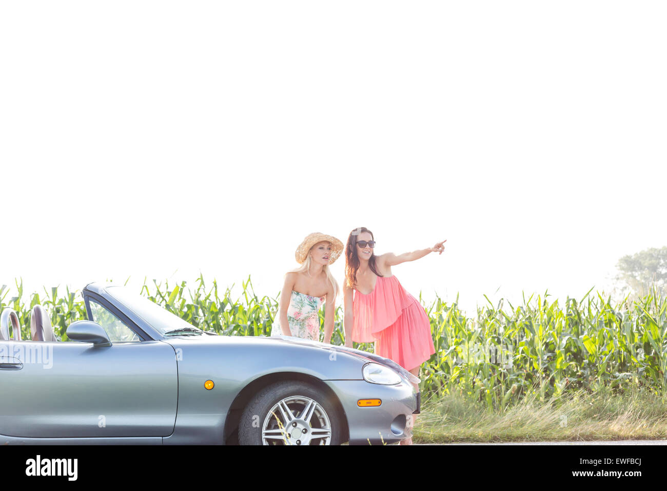 Frau, die etwas zu Freundin stehend Cabrio Stockfoto