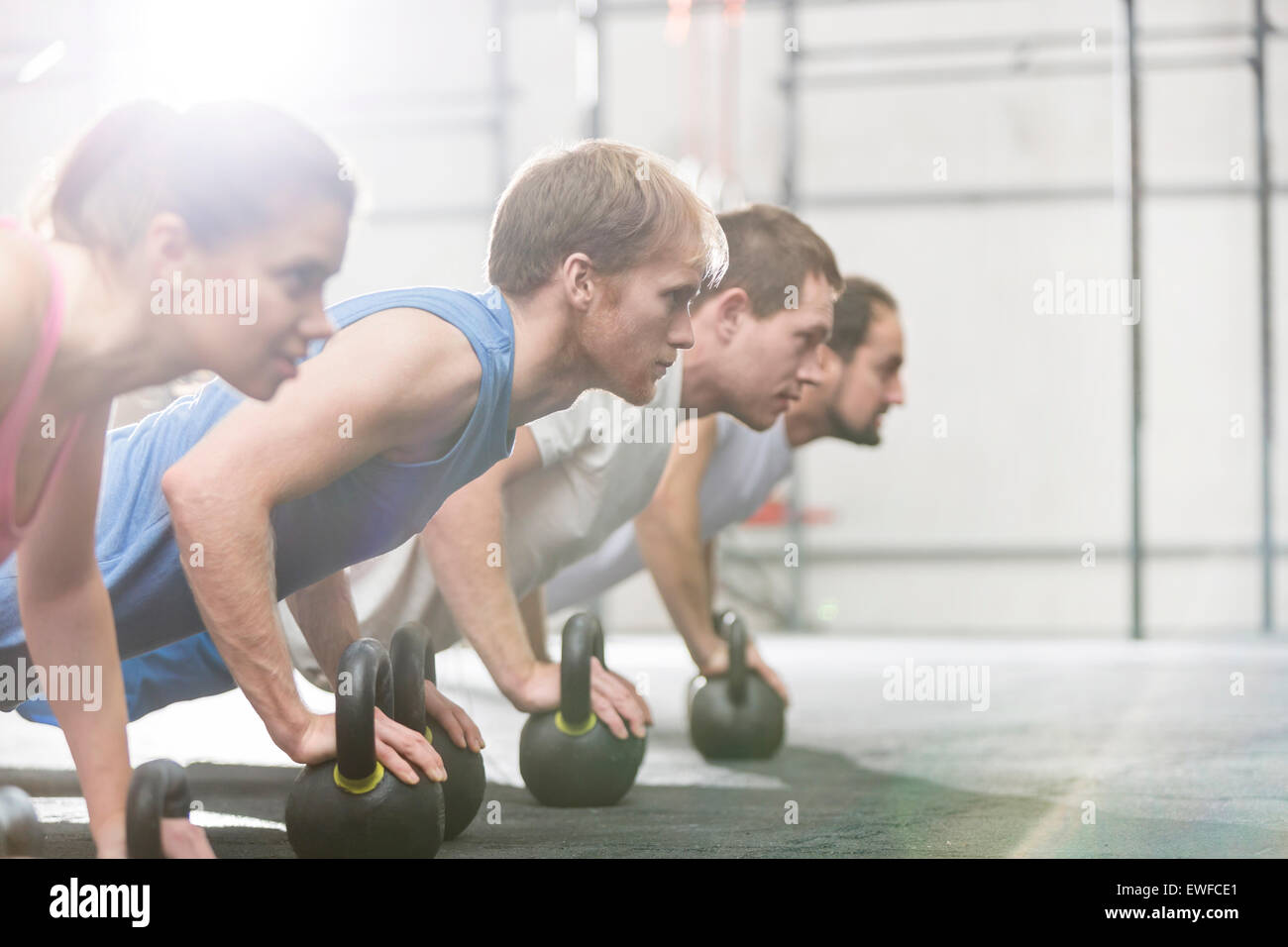 Engagierten Menschen tun Liegestütze mit Kettlebells bei Crossfit gym Stockfoto