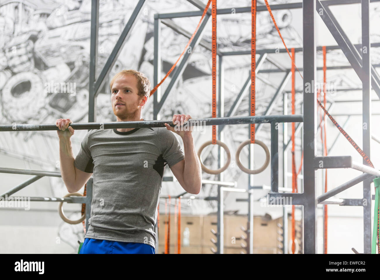 Zuversichtlich Mann tut Klimmzüge in Crossfit gym Stockfoto
