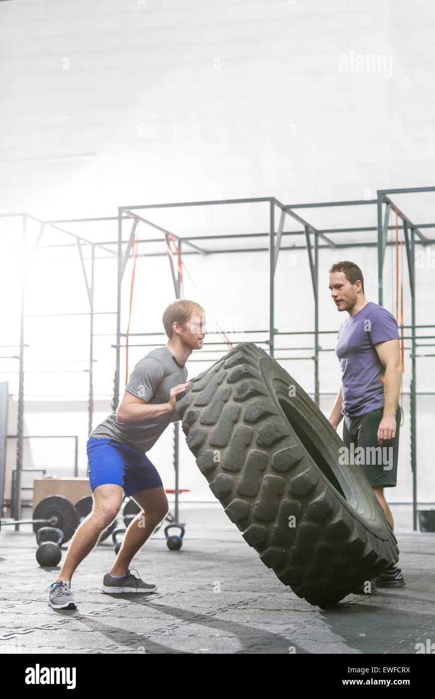 Mann sucht engagierte Freund spiegeln Reifen in Crossfit gym Stockfoto