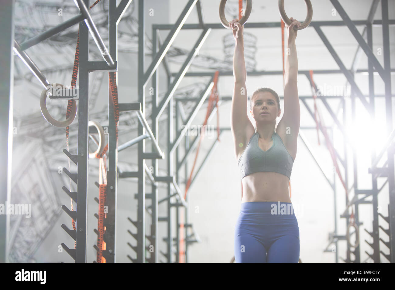 Selbstbewusste Frau mit Gymnastik Ringen im Crossfit Gym trainieren Stockfoto