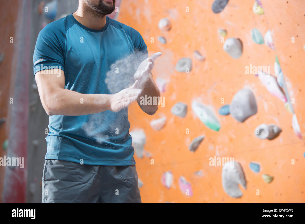 Mittelteil der Mann Bestäubungspuder von Kletterwand im Crossfit gym Stockfoto