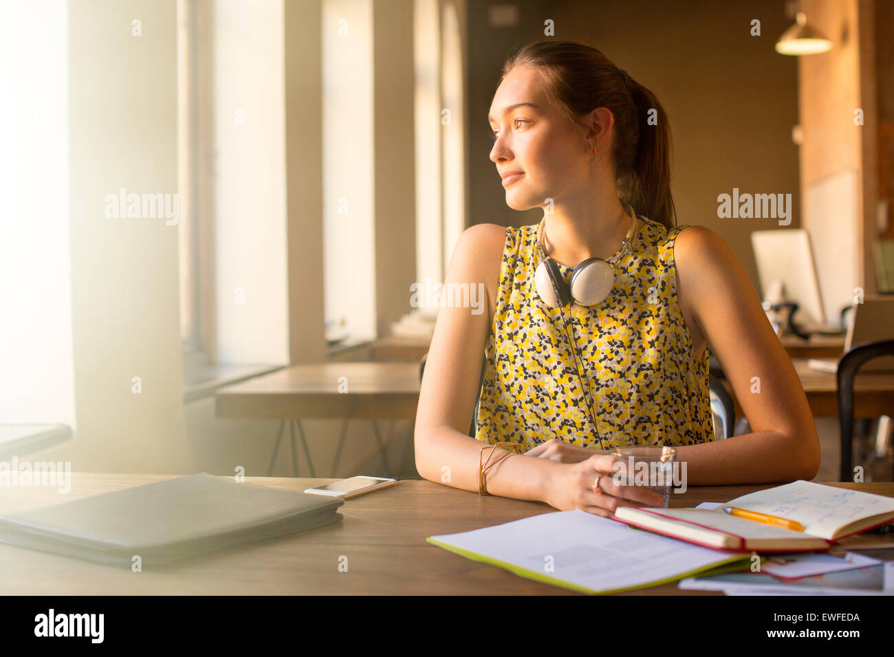 Nachdenklich lässig Geschäftsfrau mit Kopfhörern wegschauen im Büro Stockfoto Nachdenklich lässig Geschäftsfrau mit Kopfhörern wegschauen im Büro Stockfoto