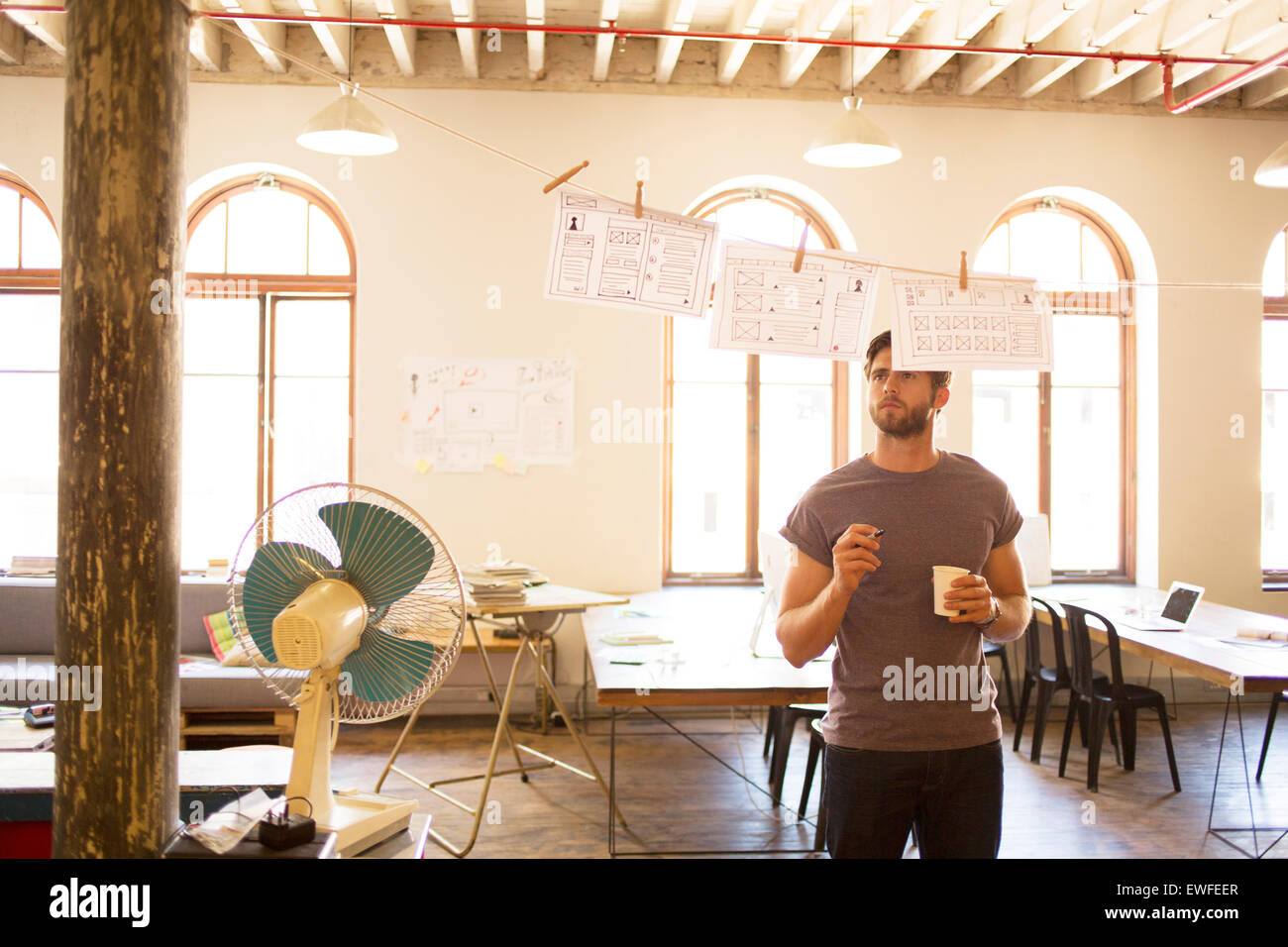 Nachdenklich kausale Geschäftsmann Überprüfung hängenden Diagramme im Großraumbüro Stockfoto