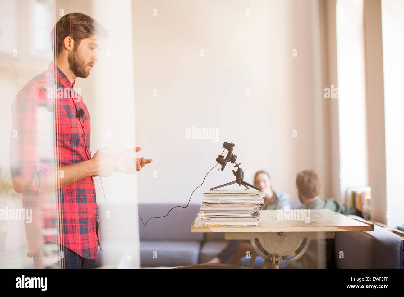 Kreative Geschäftsmann Videoaufnahme mit Handy im Büro Stockfoto