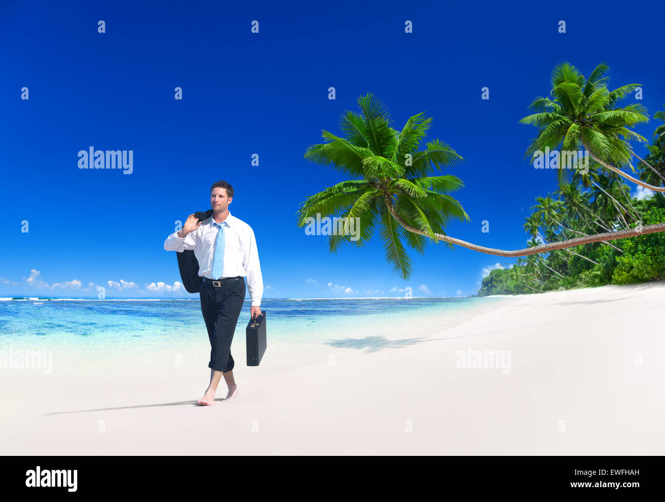 Geschäftsmann am tropischen Strand entlang spazieren. Stockfoto