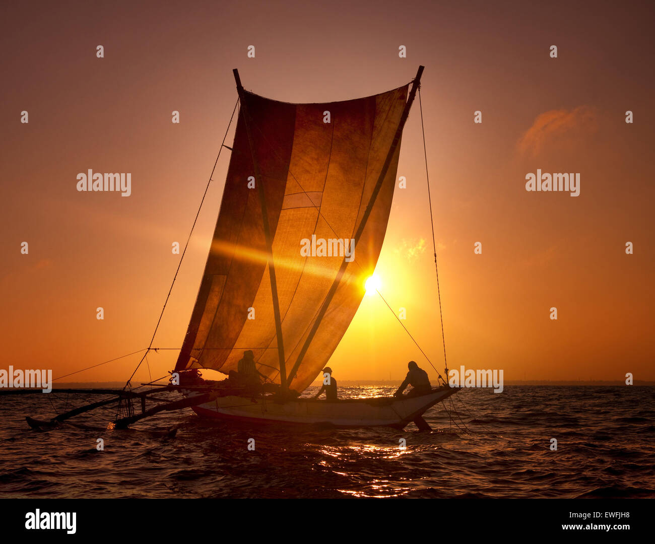 Fischer auf einem Katamaran bei Sonnenuntergang. Stockfoto