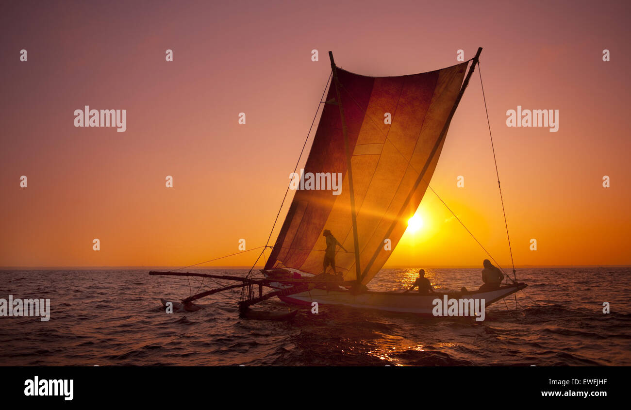 Fischer auf einem Katamaran bei Sonnenuntergang. Stockfoto