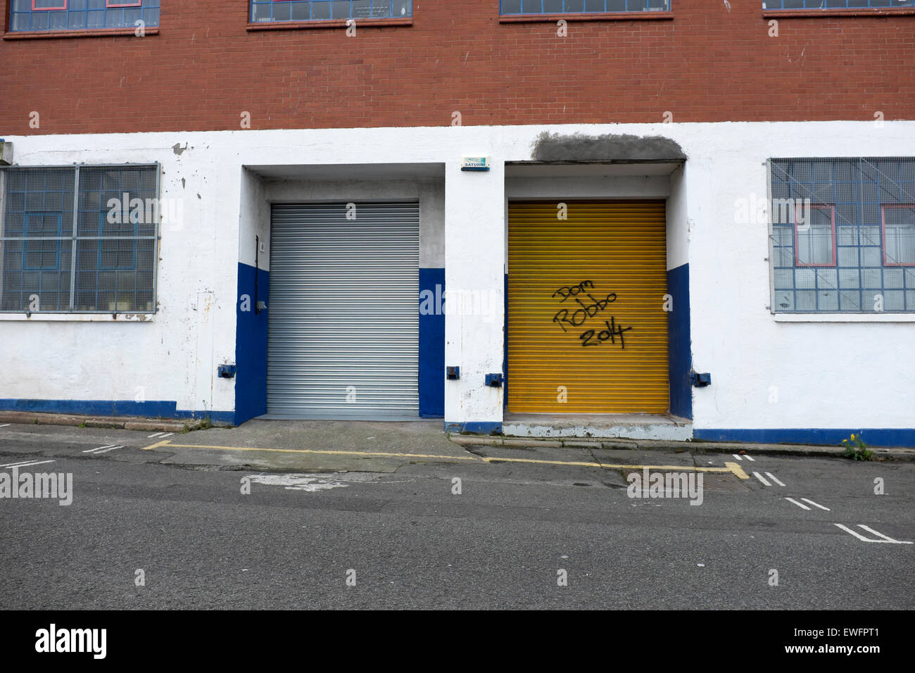 Weiße Wand gelbe Tür Industrie große Auslöser Stockfoto
