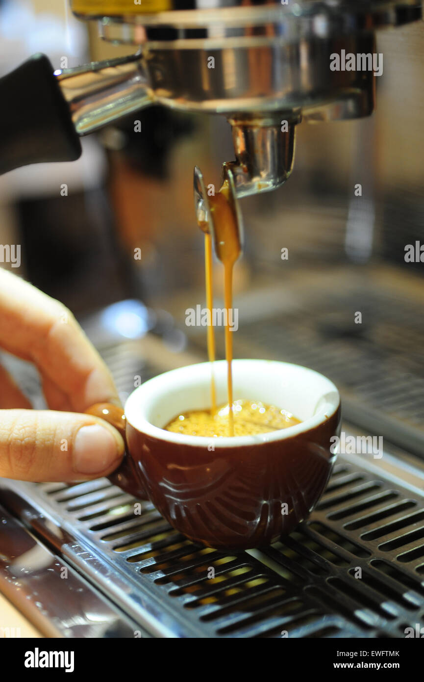 Lebensmittel, Kaffee Cafe Espresso Getränke serviert in einer Demitasse Keramik Tasse mit halten die Tasse barista Stockfoto