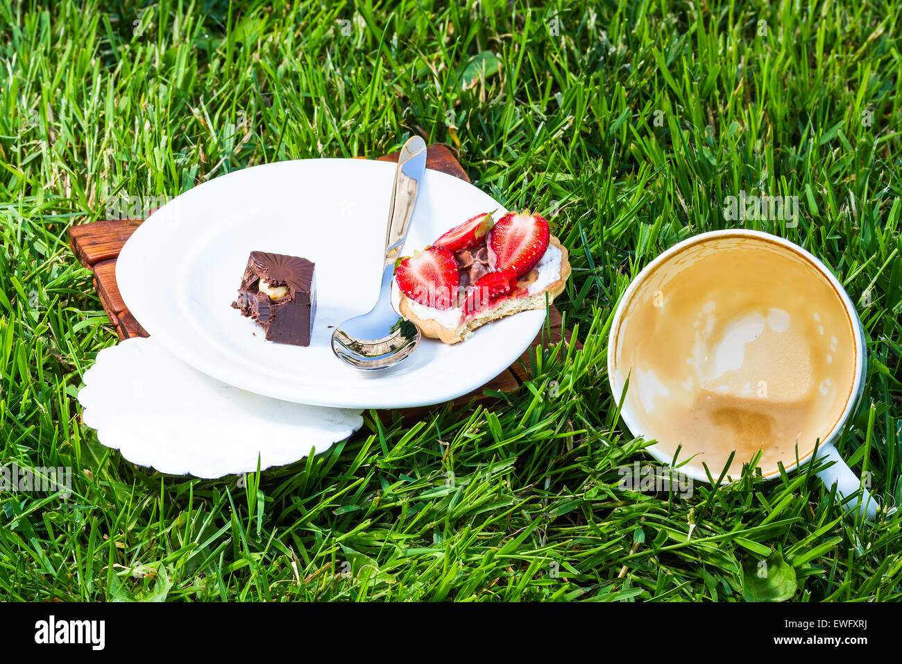 betrunken Cappuccino und süßes Dessert auf Rasen Hintergrund Stockfoto