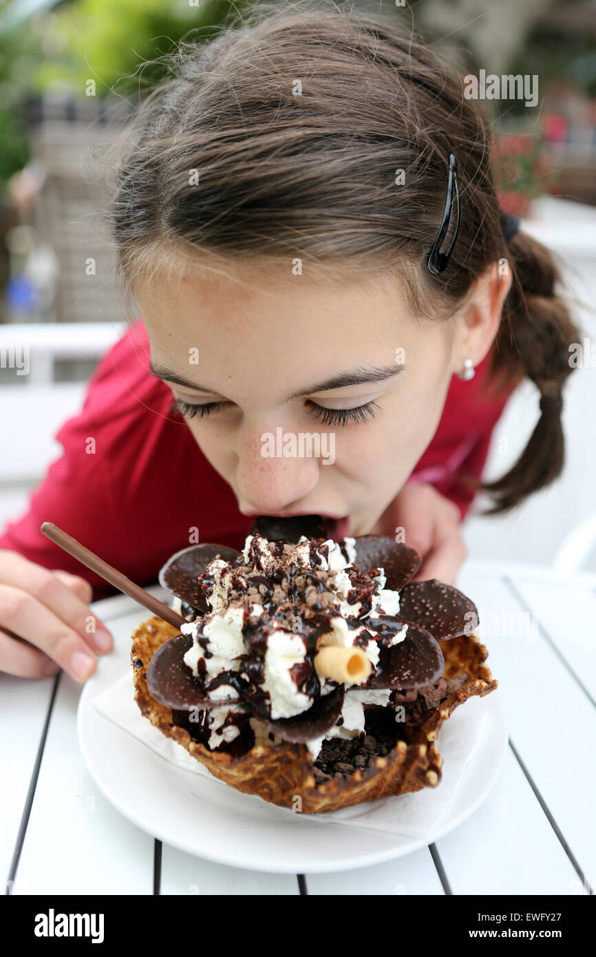 Werl, Deutschland, Mädchen isst eine Waffel mit Schokolade und Sahne Stockfoto