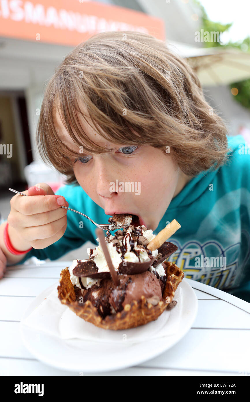 Werl, Deutschland, junge Essen eine Waffel mit Schokolade und Sahne Stockfoto