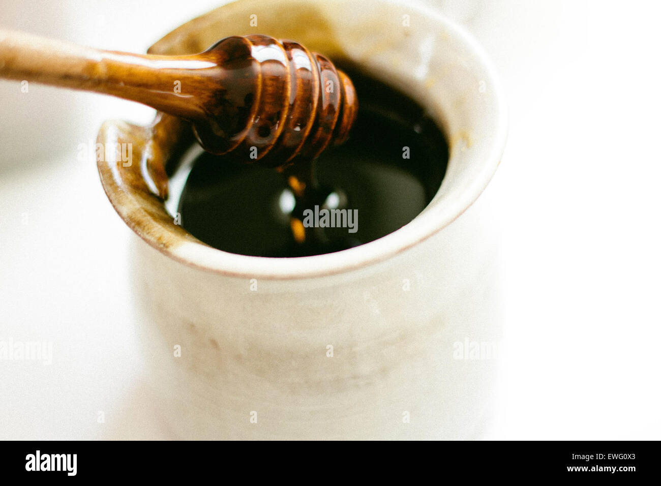 Honig-Stick in Glas Honig getaucht Stockfoto
