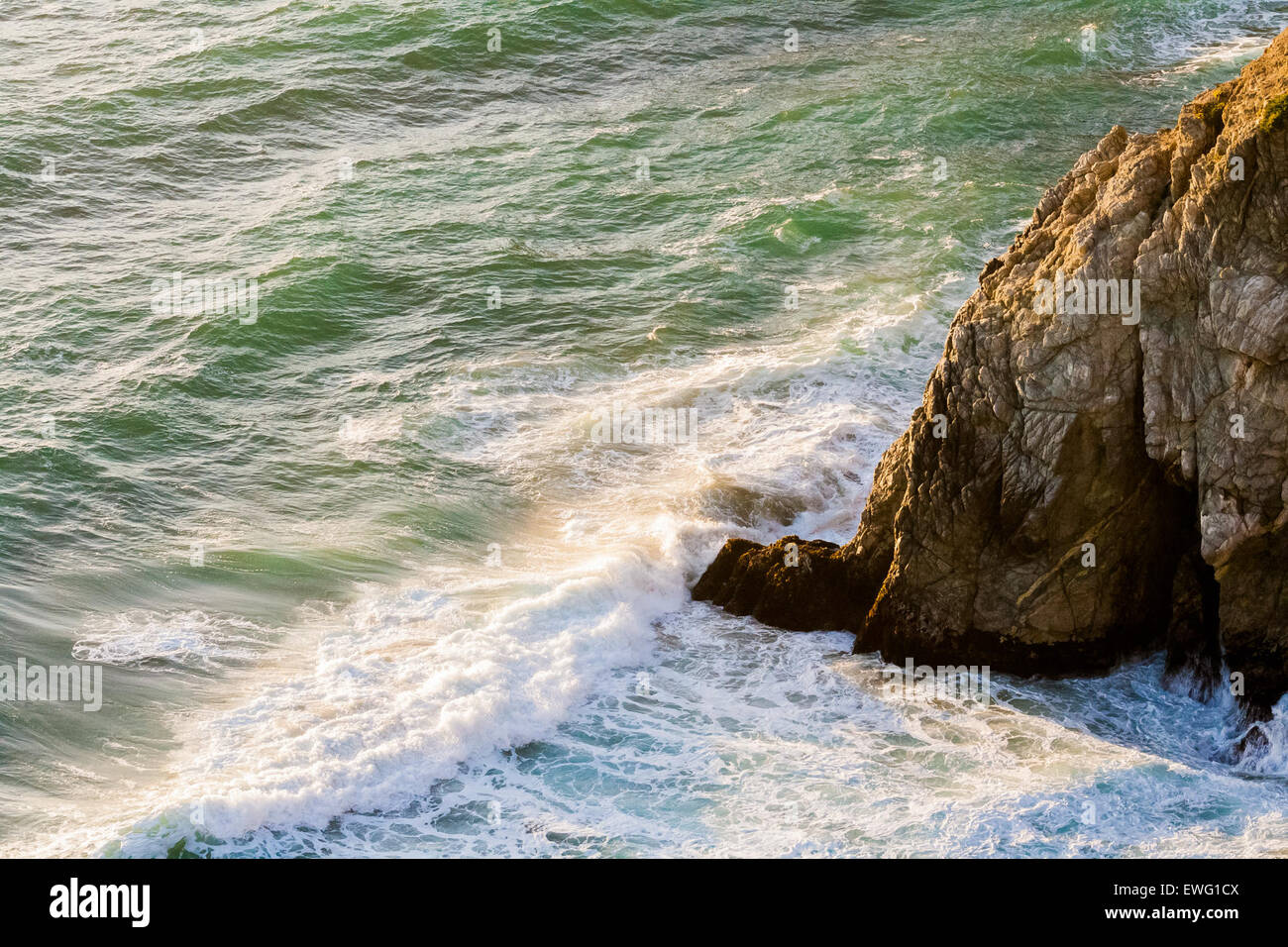 Im freien Meer Ozean Wellen gegen felsigen Ausläufer Felsvorsprung Rock Flut Wasser Wildwasser Hintergrund Meereswellen Stockfoto