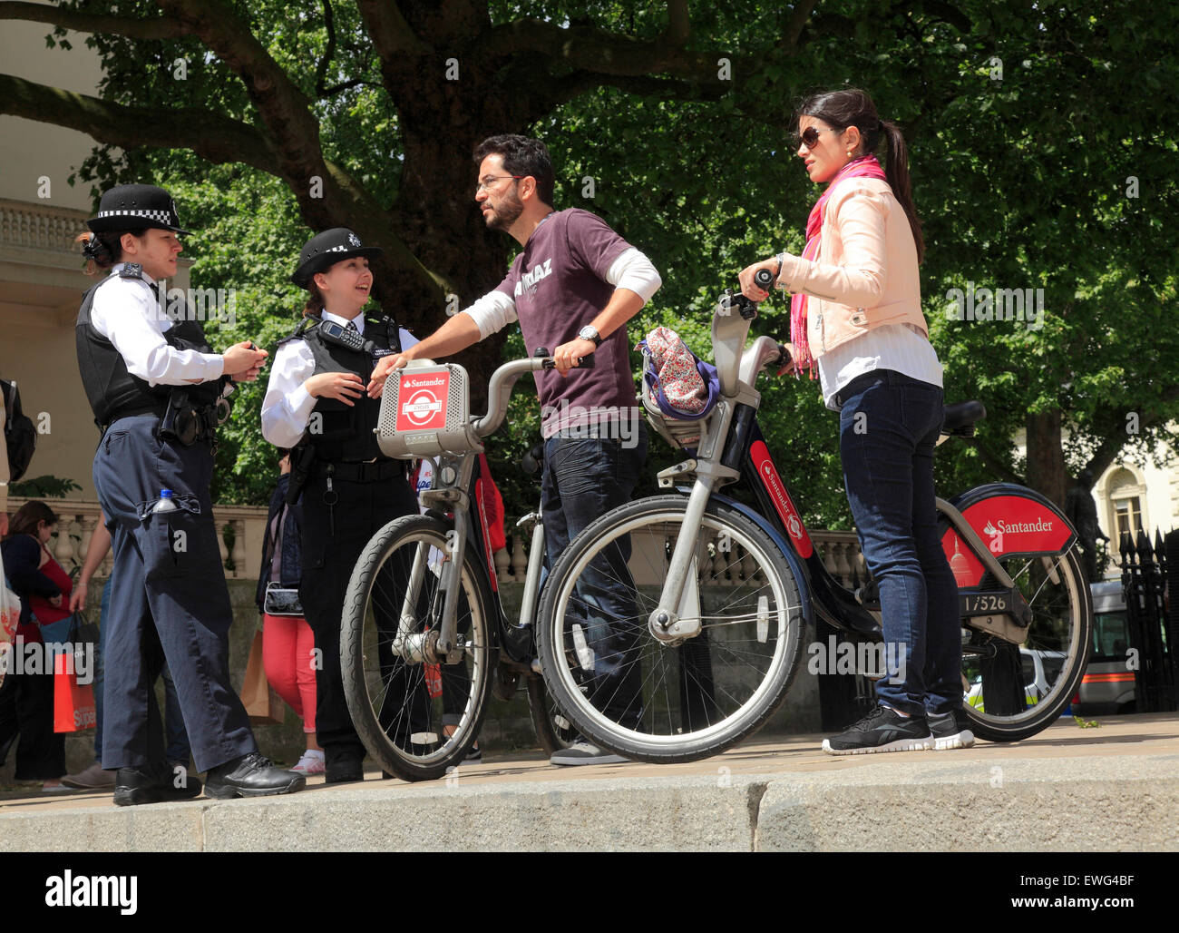 Zwei Polizisten geben einige Frauen dazu beitragen, Touristen in London Stockfoto